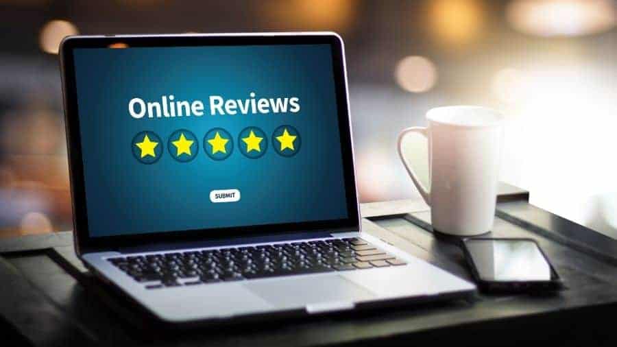 A  laptop computer displaying the message "Online Reviews" with five yellow stars underneath the message. 