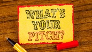 The words "What's Your Pitch?" written on a yellow piece of paper.