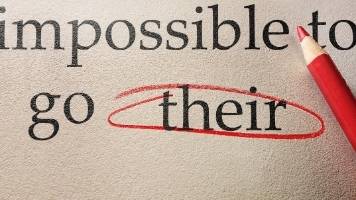 The word their (spelled t-h-e-i-r) circled in red pencil because the word there (spelled t-h-e-r-e) is correct. 