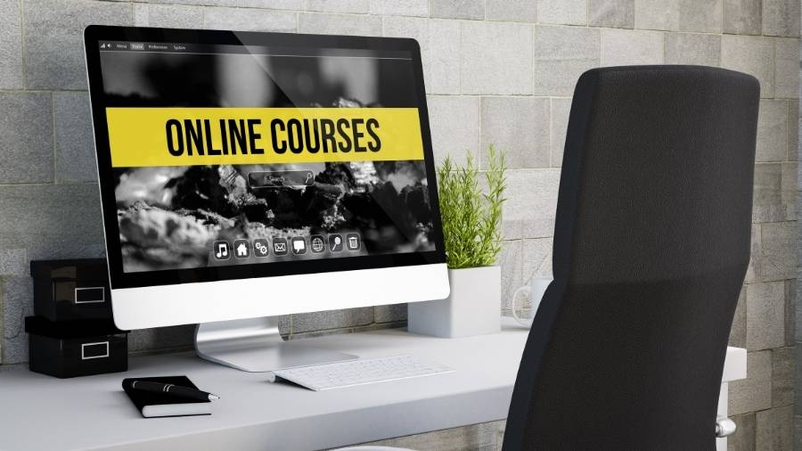 A sleek desktop computer with the words "Online Courses" written across the screen. 