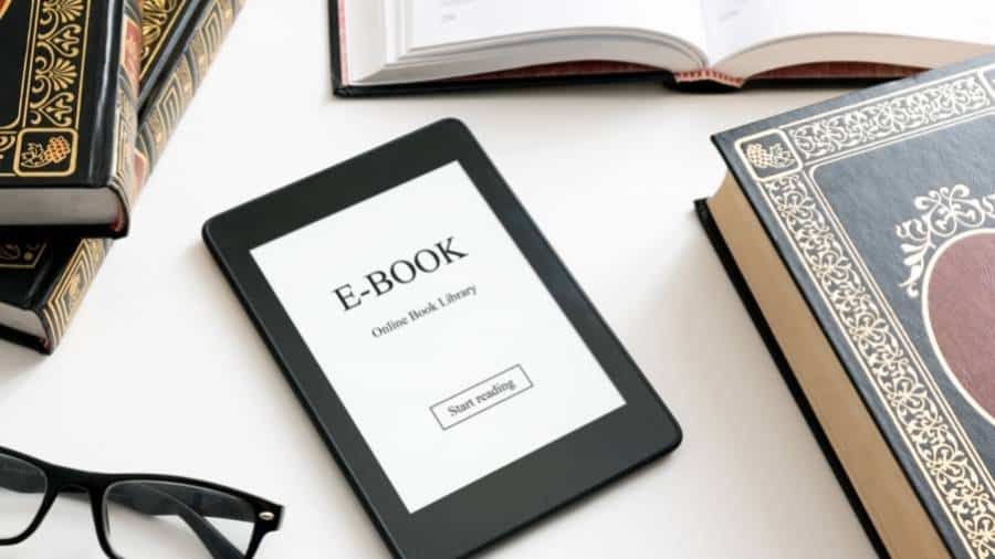 A pair of glasses, four antique books, and a tablet with the word "E-Book" on the screen.