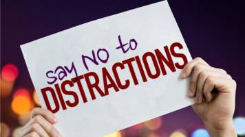 Someone is holding a sign that says, "Say no to distractions."